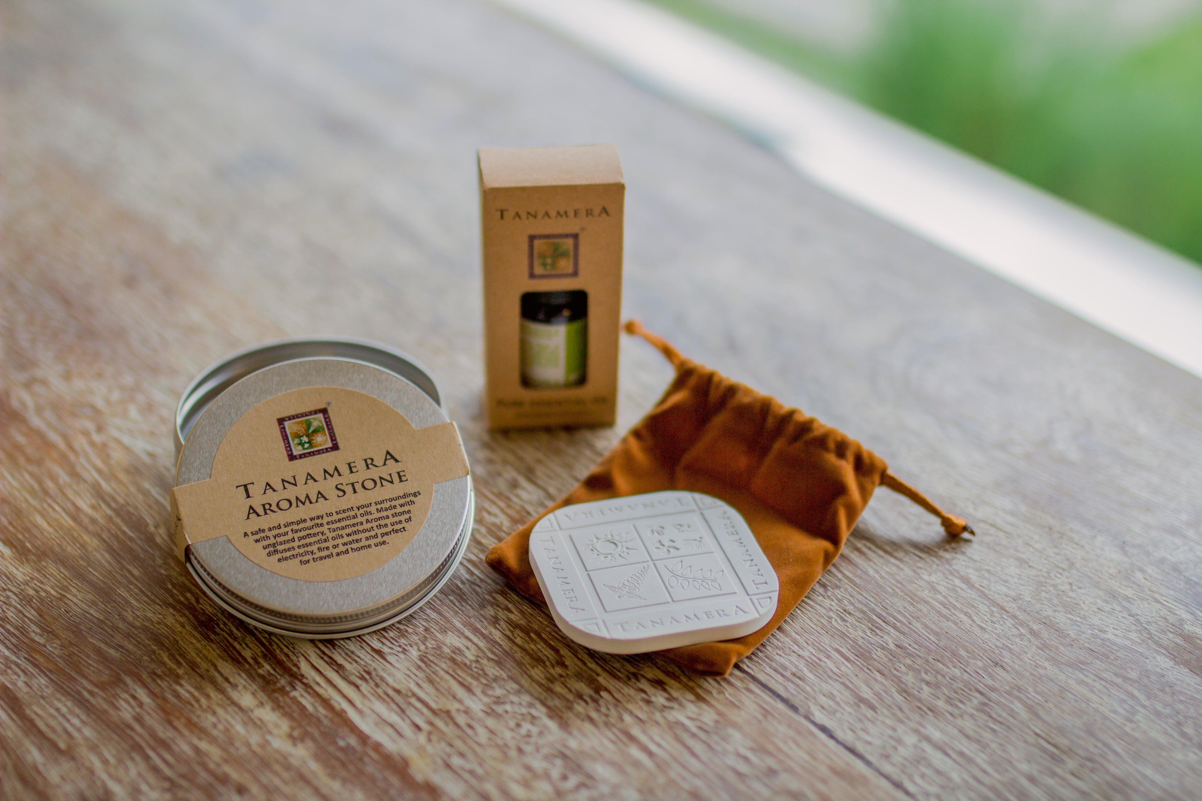 Tanamera Aroma Stone product on a wooden surface with packaging and a drawstring bag.