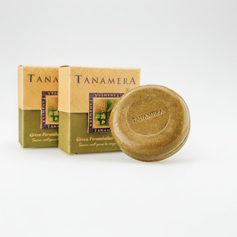 Tanamera Green Formula body soap bar shown in front of its retail box packaging on a white background, with two small line-drawn icons on the right describing benefits.